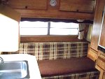 100 1542 .The cushions here are all original the brown seat cover is just slightly sun faded, upper cabinet folds down to a bunk