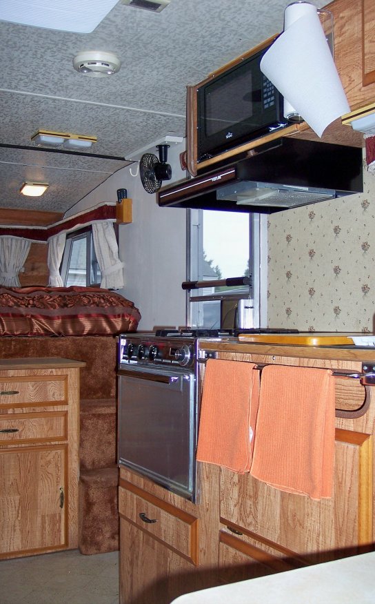 1984 Sunline F-1850 Fifth Wheel. Looking towards front from dinette area, showing kitchen, new installed microwave, stairs to sleeping loft. Above the stairs is newly installed TV remote holder and 2 speed 12vdc fan. Fan manually swivels, you can aim toward sleeping loft or toward dinette.
100 9060