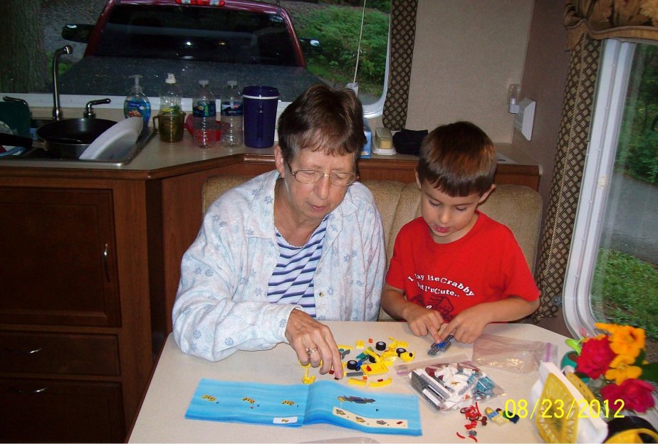 Grandma and Elijah building a Lego camper and tow vehicle.