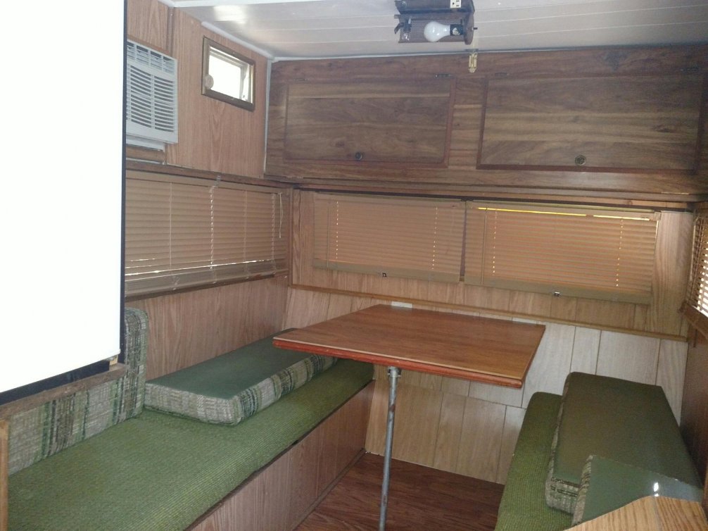 Area above table is fold down bunk. Pretty sure it is original. All the light paneling and pergo floor looks good but is hiding previous damage that was not removed.